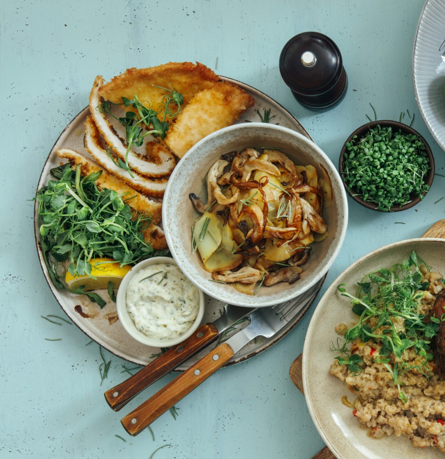 Chicken in a Parmesan and Breadcrumb Crust  served with Crispy Potatoes and Rocket. Beer-braised Beef Cheek with Pearl Barley Risotto. Roasted Pear and Parma Ham Salad with Goats Cheese and Almond Flakes. Salad with Roasted Prawn. Flat lay top-down composition on blue background.